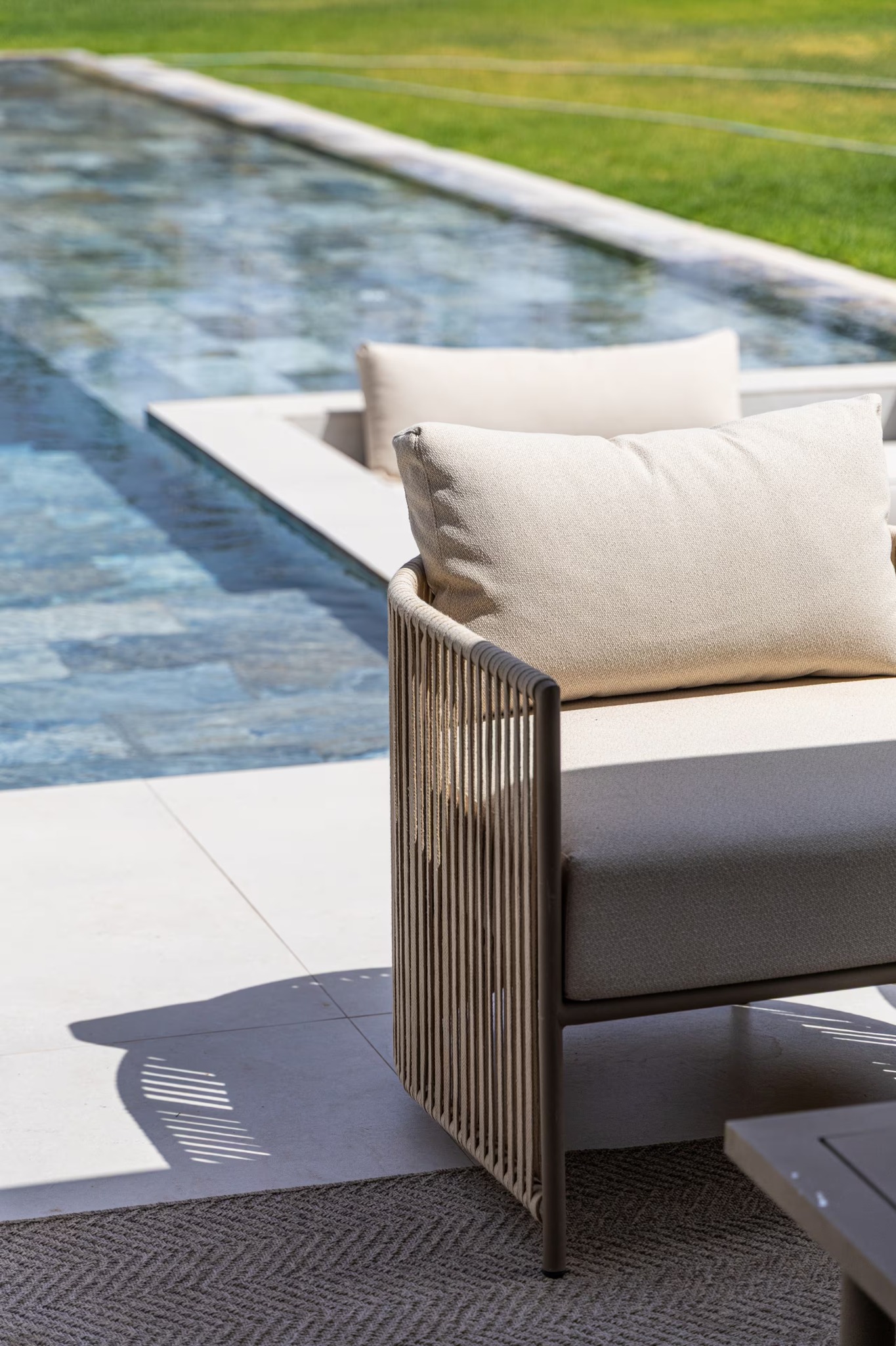 Cushioned seating beside the villa’s private swimming pool